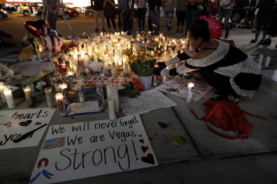 A woman places a candle at a memorial for victims of the mass shooting in Las Vegas. 
